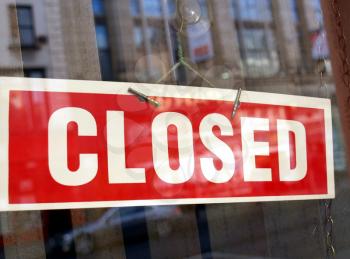 Closed sign in a shop showroom with reflections