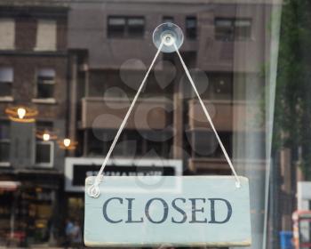 Closed sign in a shop showroom with reflections