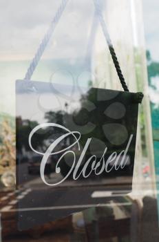 Closed sign in a shop showroom with reflections