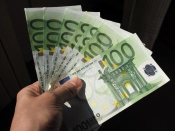 Hand holding and giving Euro banknotes money (EUR), currency of European Union