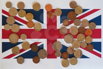 Pound coins money (GBP), currency of United Kingdom, over the Union Jack