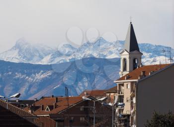 View of the city of Settimo Torinese, Italy with steple of St Peter in Chains church and the Alps mountains
