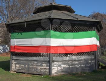 The national Italian flag of Italy on a bandstand in a park