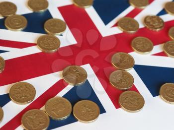 Pound coins money (GBP), currency of United Kingdom, over the Union Jack