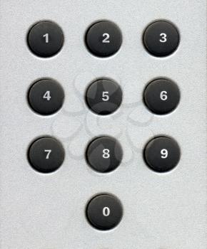 number digits on a keypad with rubber buttons over grey metal background