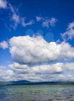 Sea and blue sky. White clouds over lake. Summer Landscape

