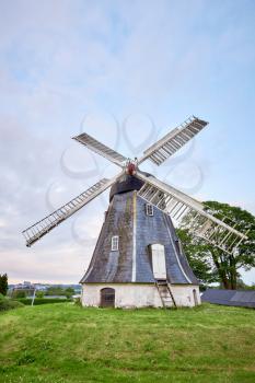 old and antique windmill next to house in denmark