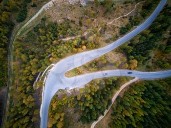 a drone shot of road in the mountains with trees