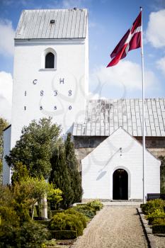 A small danish church on a sunny day celebrating a confirmation