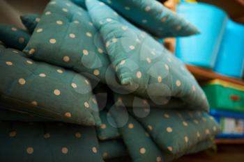 Blue and dotted pillows in a stack at a school