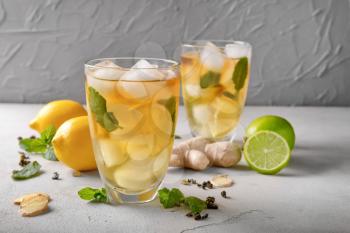 Glasses of cold lemon tea with ginger on table�