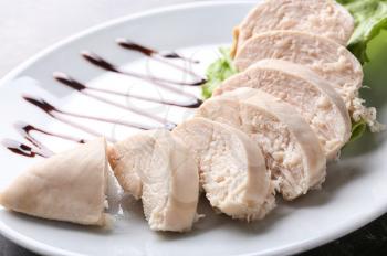 Sliced boiled chicken fillet on plate, closeup�