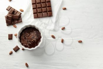 Flat lay composition with delicious chocolate on wooden background�