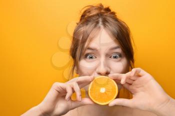 Beautiful funny young woman with citrus fruit on color background�