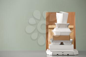 Different packages on table against color background. Food delivery service�