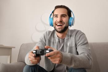 Young man playing video games at home�