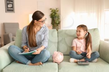 Mother and daughter counting money  indoors. Money savings concept�