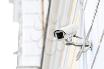 Modern CCTV camera installed on wall of building outdoors�