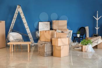 Carton boxes and interior items on floor in room. Moving house concept�