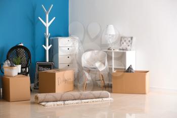 Carton boxes and interior items on floor in room. Moving house concept�