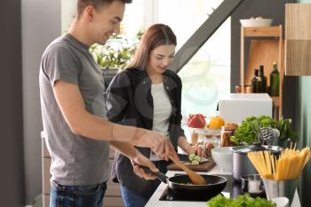 Young couple cooking together in kitchen�