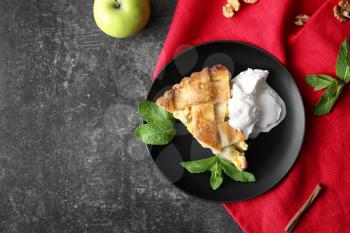 Plate with piece of delicious apple pie and ice cream on grey background�