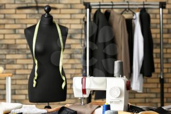 Tailor's workplace with sewing machine and mannequin in atelier�