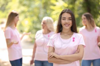 Beautiful woman with pink ribbon outdoors. Breast cancer concept�