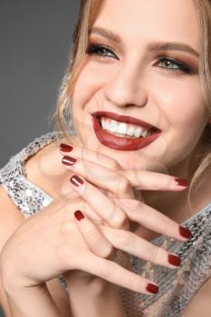 Fashionable young woman with beautiful manicure on grey background, closeup�