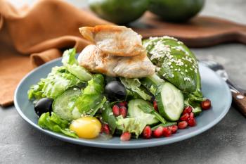 Plate with tasty avocado salad on table�