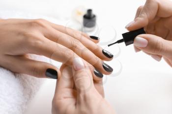 Young woman getting professional manicure in beauty salon, closeup�