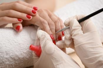 Young woman getting professional manicure in beauty salon, closeup�