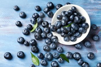 Bowl with ripe blueberries on wooden table�