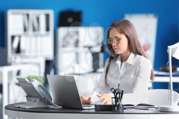 Young businesswoman working with laptop in office�