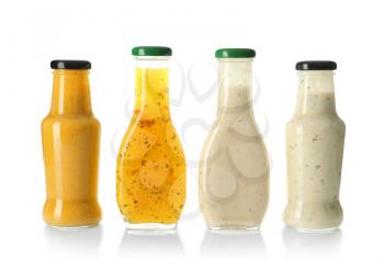 Bottles with tasty sauces on white background�