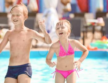 Cute children playing in swimming pool on summer day�