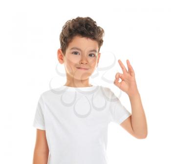 Cute little boy showing OK gesture on white background�