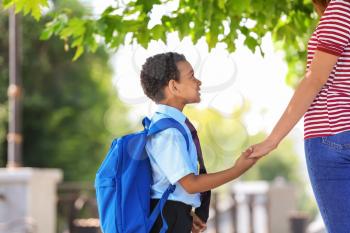 Cute African-American boy going to school with his mother�