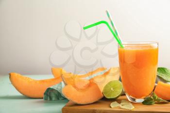 Glass of tasty melon smoothie on table�