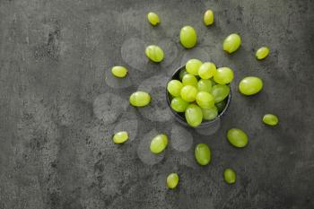 Bowl with ripe juicy grapes on grey table�