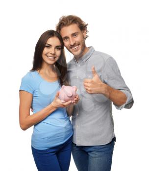 Happy young couple with piggy bank on white background�