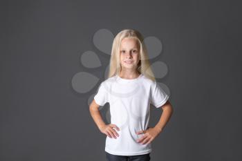 Cute little girl in t-shirt on dark background�
