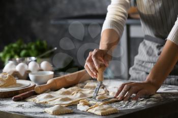 Woman making tasty ravioli on table�
