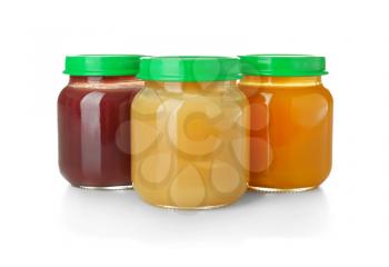 Glass jars with healthy baby food on white background�