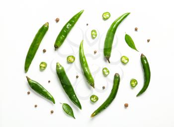 Flat lay composition with green chili peppers on white background�