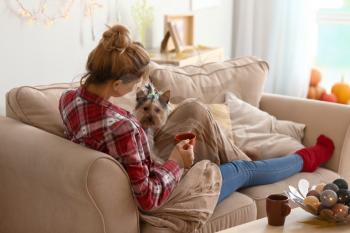 Woman with cute dog drinking tea at home�