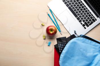 Composition with rucksack and school stationery on light background, top view�