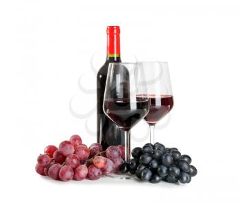 Glasses and bottle of red wine with ripe grapes on white background�