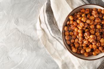 Bowl with fried chickpeas on table�