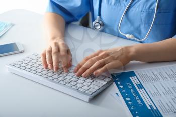 Female doctor using computer at workplace. Health care concept�
